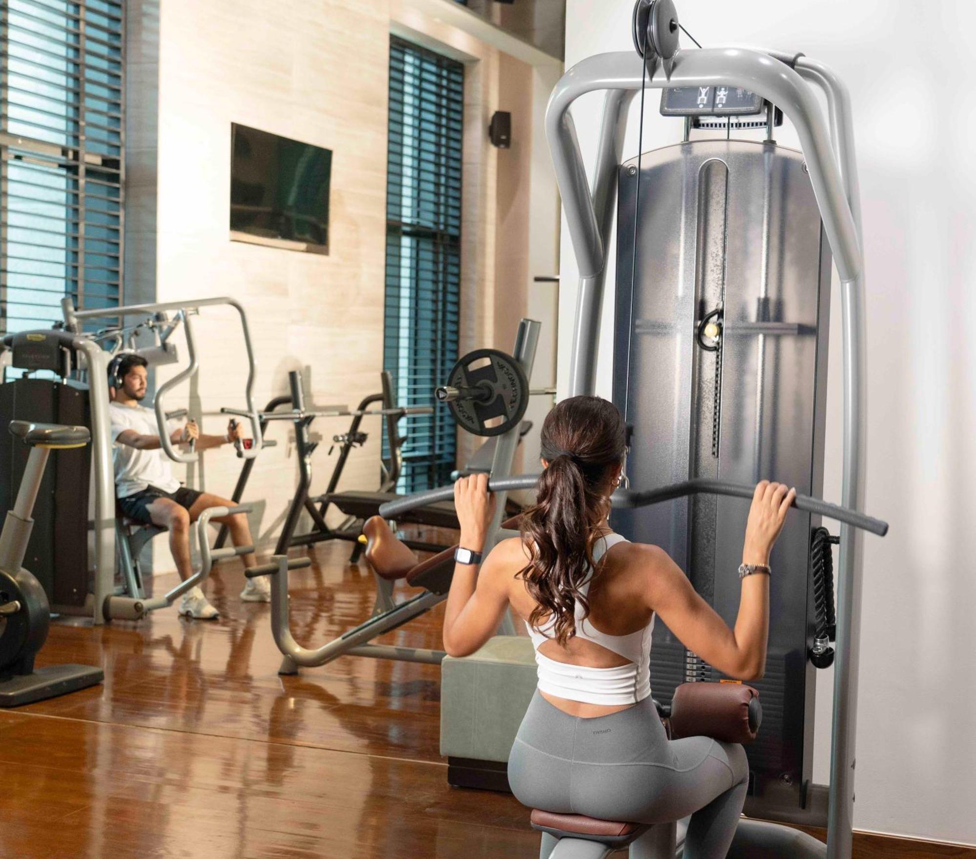 Fairmont Riyadh Eksteriør bilde A woman using a lat pulldown machine