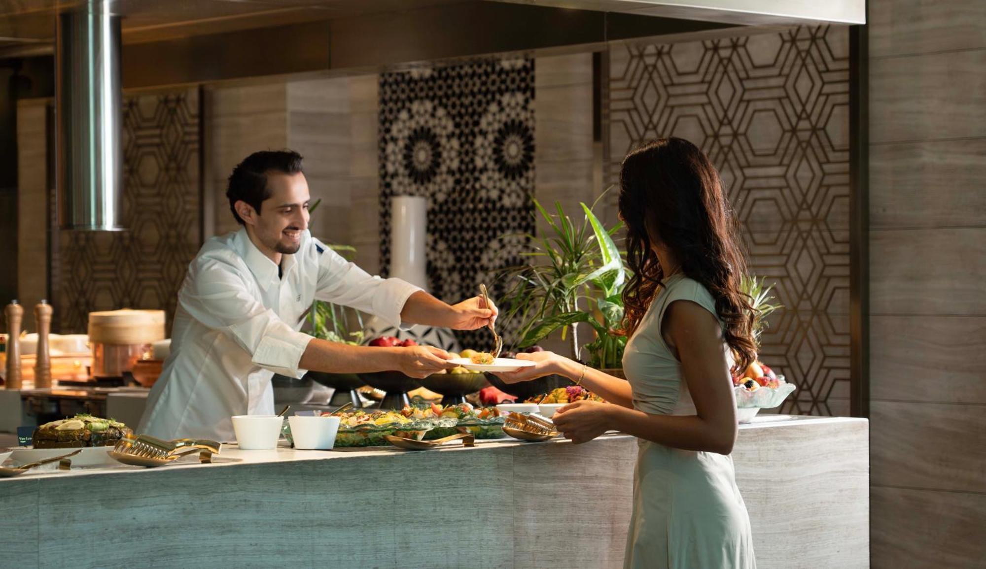 Fairmont Riyadh Eksteriør bilde A chef serving a guest at the buffet